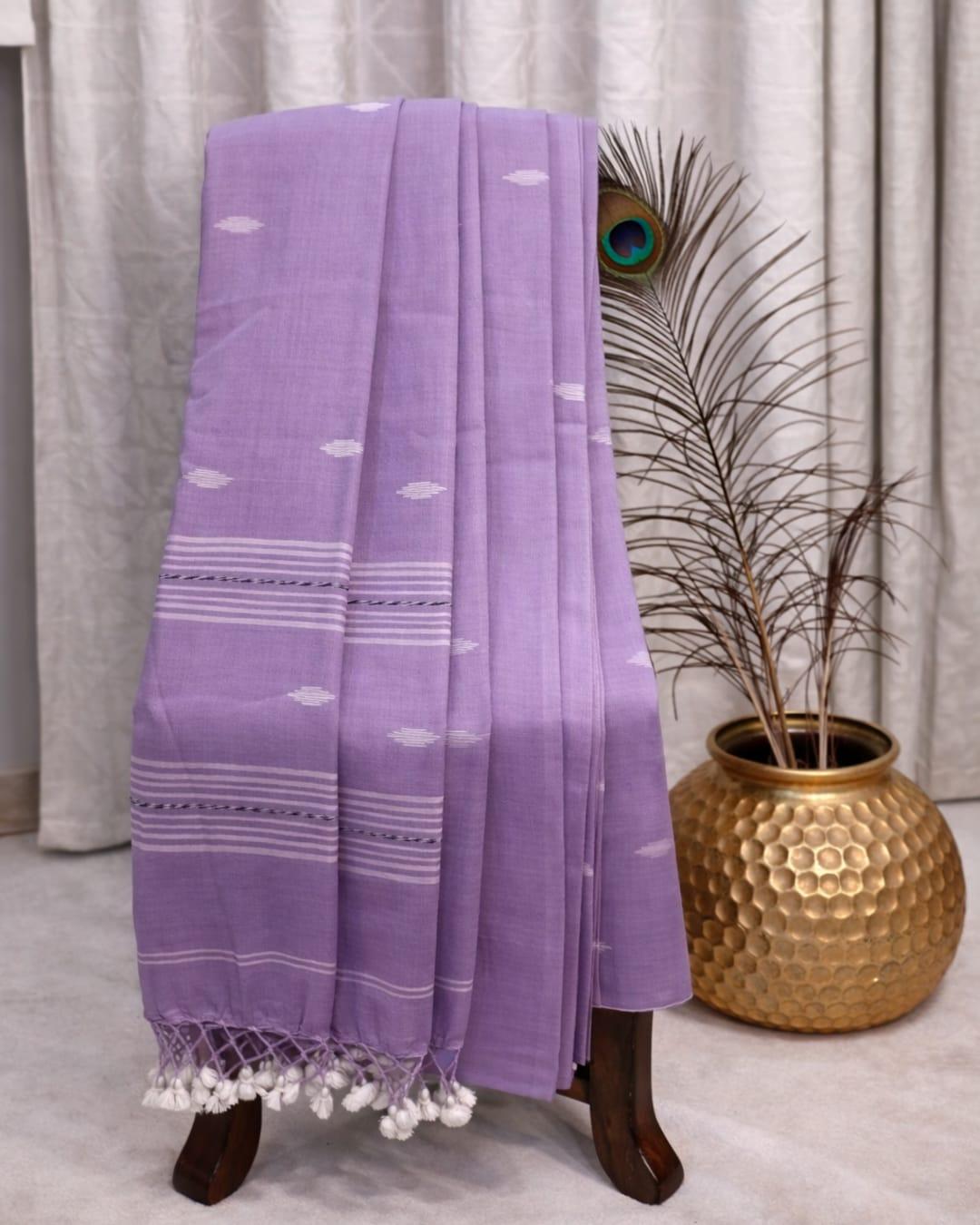 Light lavender cotton saree with white woven motifs, striped border and tassel pallu