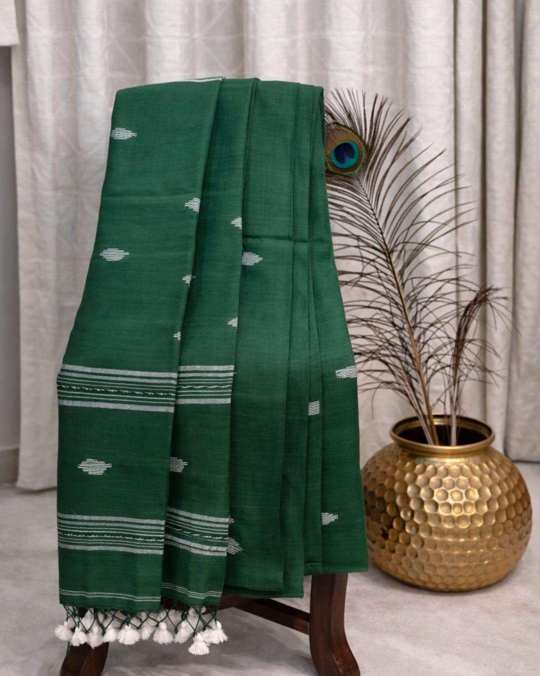 Dark green cotton saree with white ikat motifs, striped border and tassel pallu